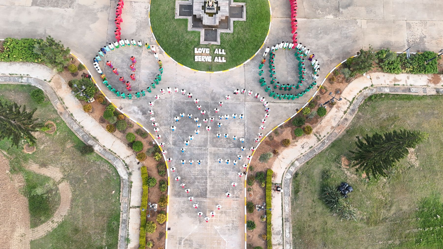 Staff forming Love All Serve All garland, aerial view