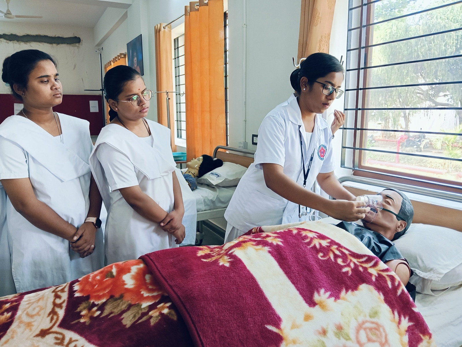 Nursing students practising oxygen administration on a manikin in the Adult Health Nursing laboratory