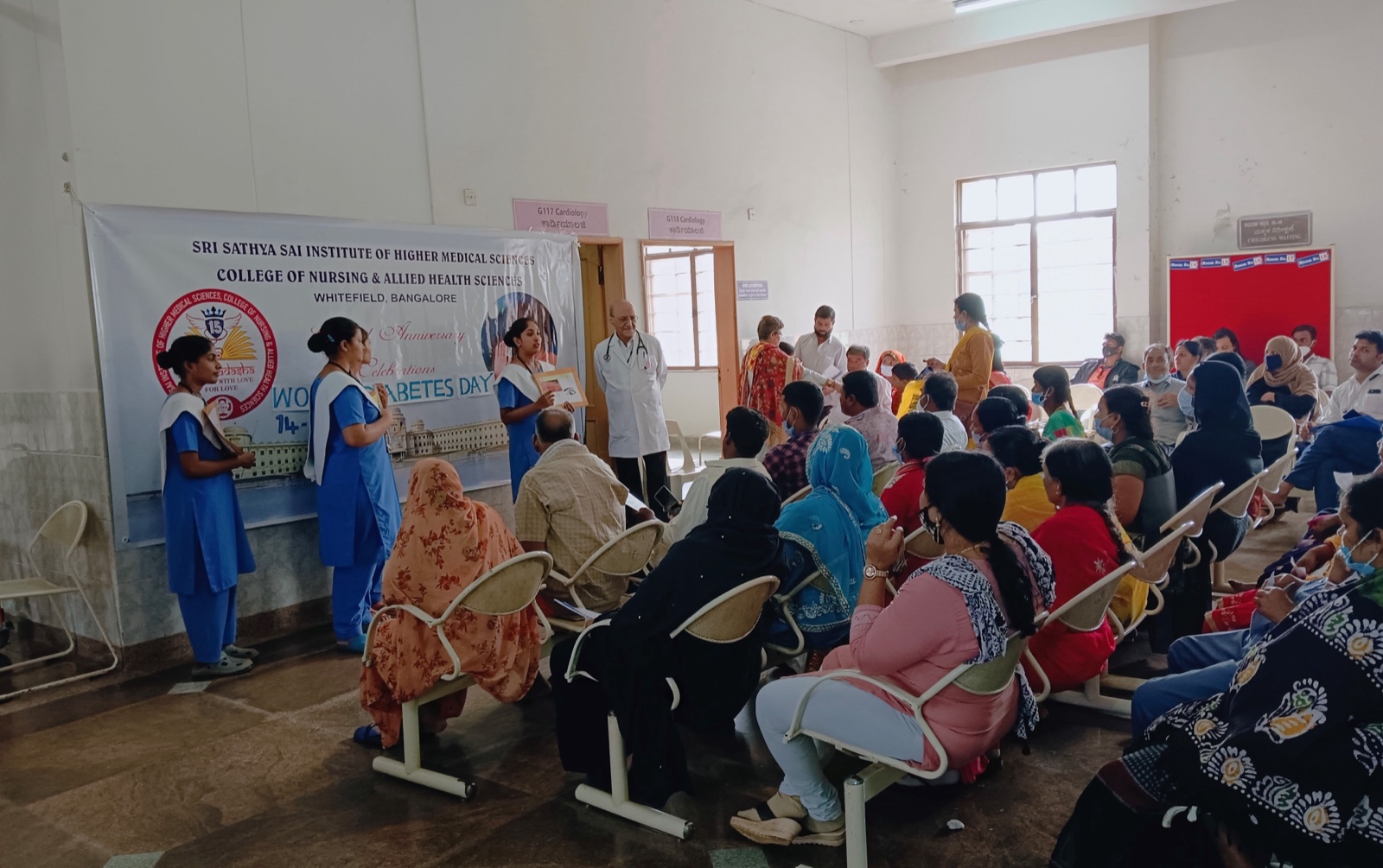 Nursing students giving a World Diabetes Day health talk to people waiting in the OPD