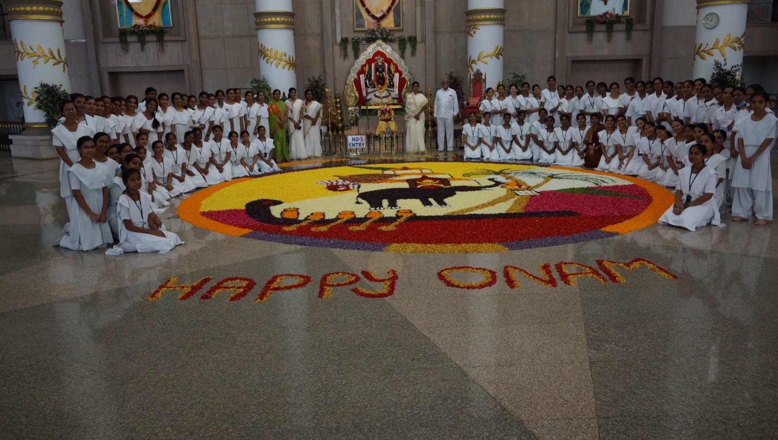 Nursing students around a floral pookalam for Onam