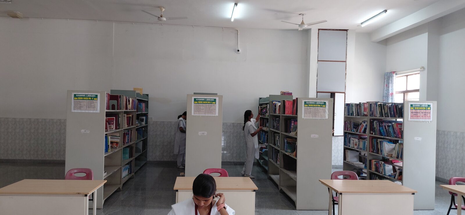Nursing students at the book racks and study tables in the library